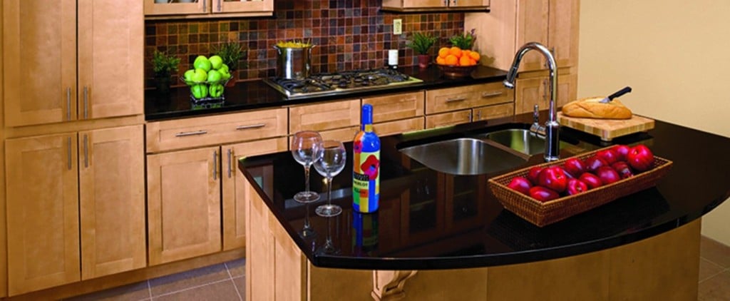 natural maple kitchen cabinets with black granite island tops