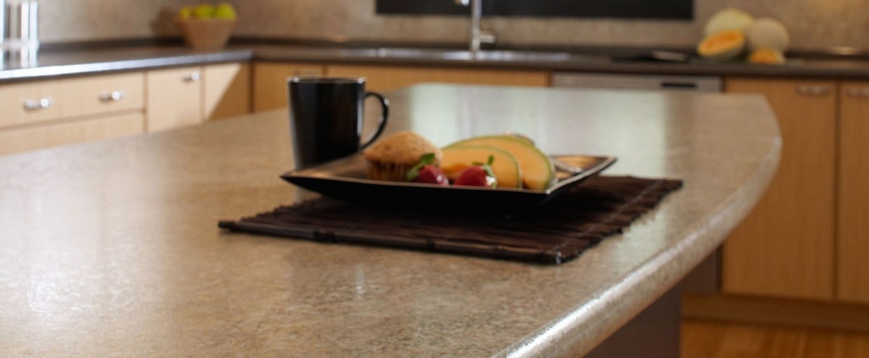 close up of a brown laminate kitchen countertop with a plate of food and a cup of coffee on top