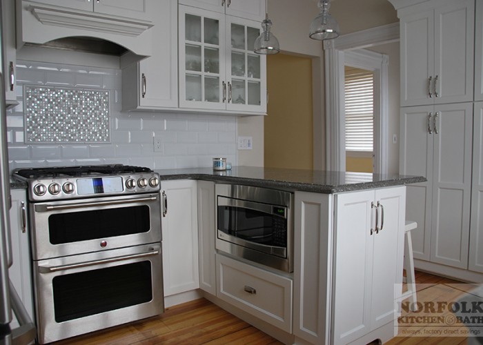 island in white kitchen with microwave in base cabinet