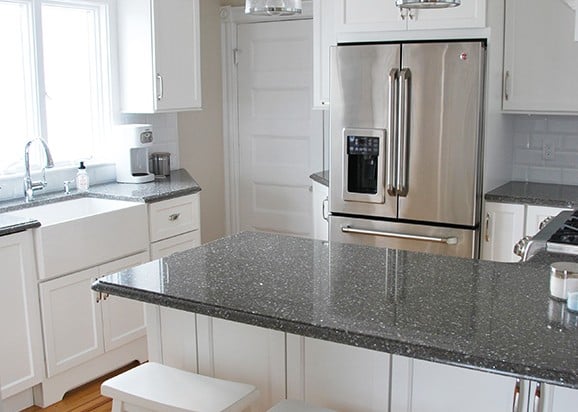 close up of white kitchen with dark granite tops