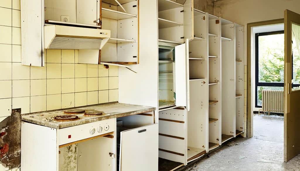 old dirty broken kitchen cabinets and hole in wall 