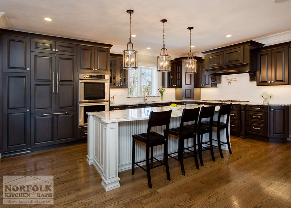 dark brown cherry cabinets with white beaded island and hardwood floors