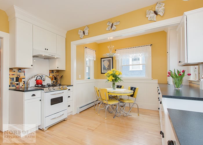 white 50s kitchen with eat in nook and yellow table
