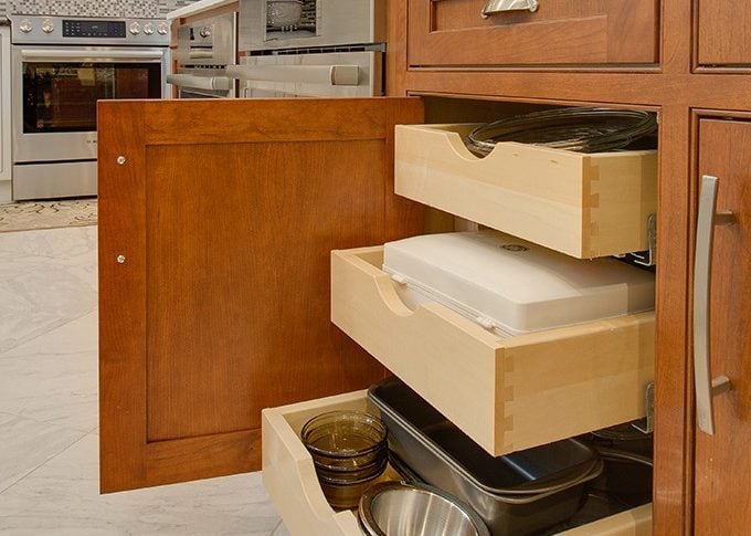 close up of 3 wood pull out drawers in cherry cabinets