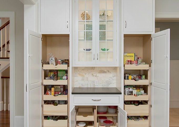 super sized white tall pantry cabinets with standard cabinets in middle with glass wall cabinets