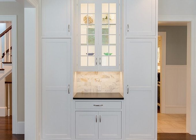 tall white cabinets doors closed and glass doors in between
