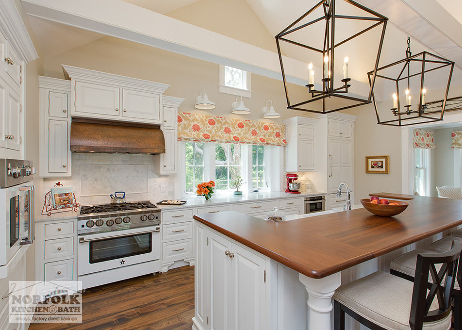 pretty farmhouse white kitchen and copper hood and cherry finish island tops