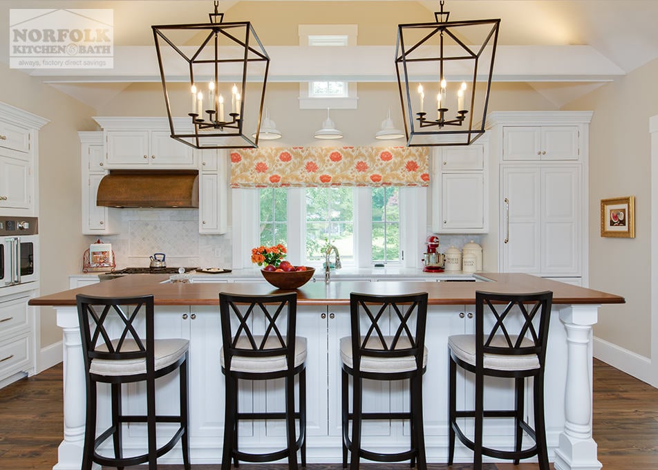 back side of white kitchen island showing large candle type decorative pendant lights over island