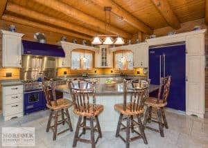 a log home kitchen with linen cabinets and striking blue Viking appliances