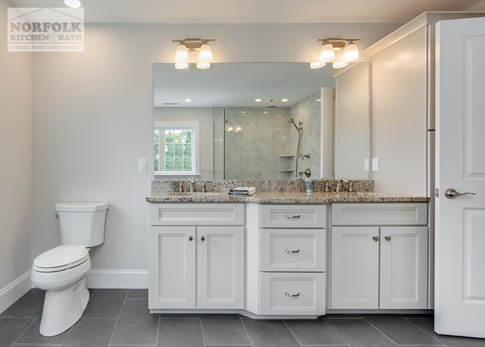 a double bathroom vanity with a granite vanity countertop next to a white toilet