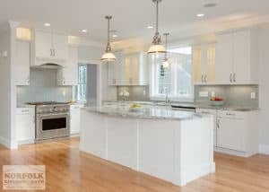 White kitchen island in white kitchen and hardwood floors