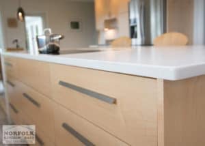 light maple cabinet from the side with contemporary drawer and stainless pull