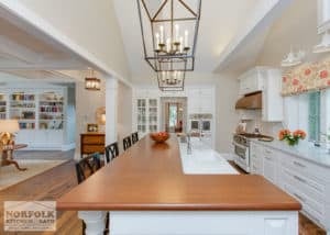 Multi-level kitchen island with warm cherry toned butcher block countertop