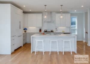 White kitchen design style with island and white stools and hardwood floors