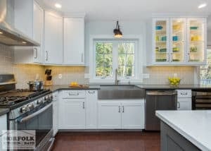 white kitchen featuring stainless appliances and cherry colored flooring and glass door cabinets