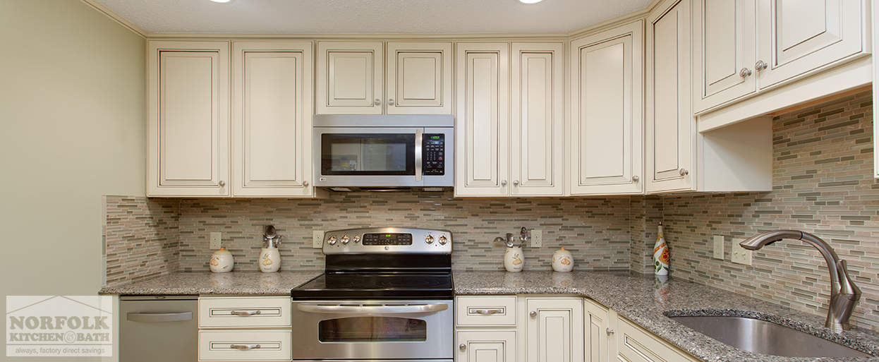kitchen cabinets in a linen finish with granite countertops and a tile backsplash