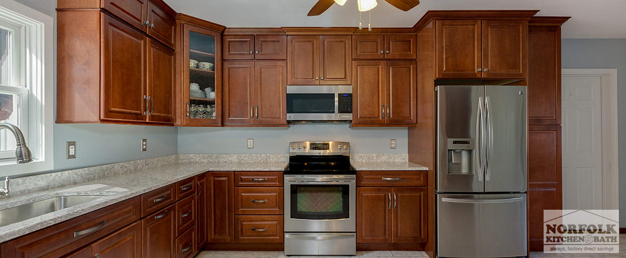 cherry kitchen cabinets with a stainless steel electric stove and an over the range microwave