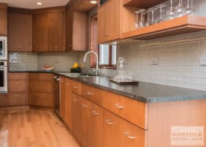 Medium toned slab door style cabinets with dark granite and hardwoood floors