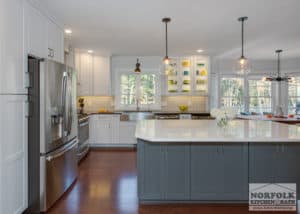 white L-shape kitchen and blue island cabinets