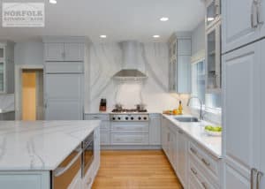 light grey kitchen with beautiful white marble looking full backsplash behind stainless hood