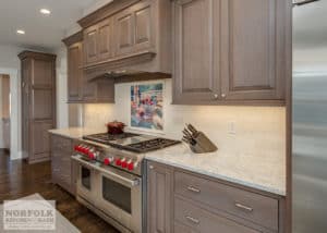 greyish wood stained cabinets with large wood custom hood