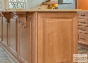 Lightly stained maple cabinet on island with decorative corbels to support island top