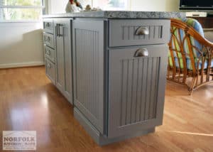 cottage kitchen island with light grey cabinets with beaded door style