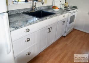 cottage kitchen with white beadboard style doors and cup handles