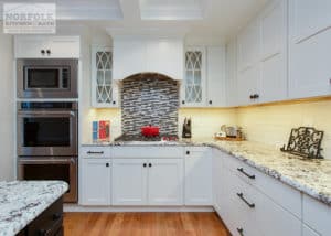 White kitchen with decorative tile behind cooktop