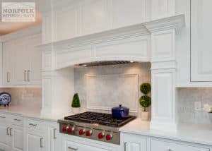 White cabinetry over a cooktop with lots of decorative molding