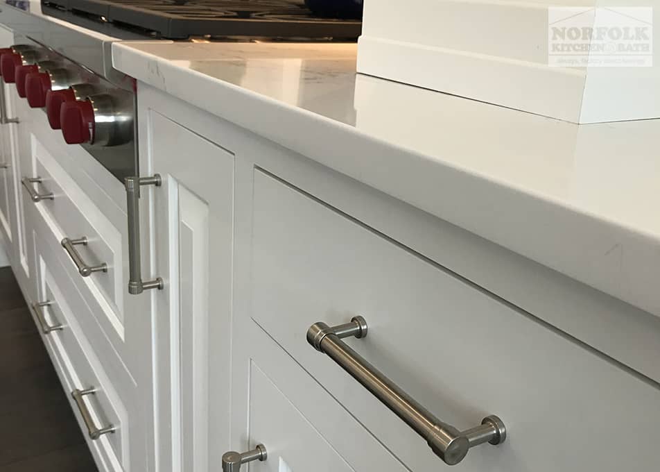 white kitchen cabinets with stone countertops and nickel hardware