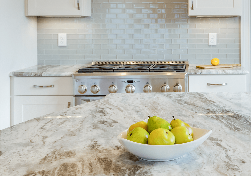 close up of a fantasy brown granite kitchen countertop with a bowl of green pears on top