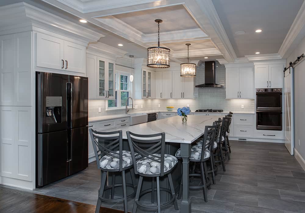 beautiful white kitchen with island and grey floors detailed tray ceiling