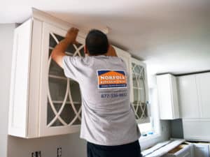 kitchen contractor installing molding with Norfolk logod tee