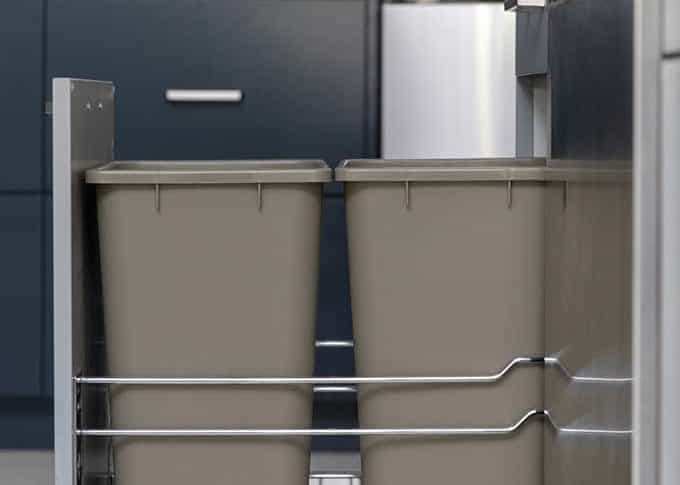close up side view of a double trash pull out cabinet in a contemporary blue kitchen