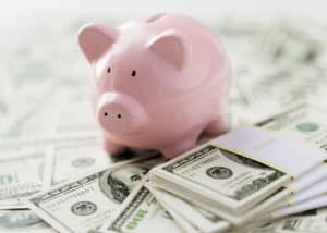 Pink Piggy Bank on pile of cash