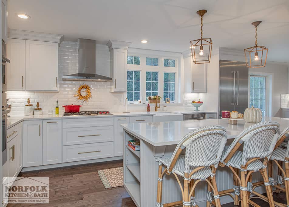 a white kitchen with island and stainless steel range hood