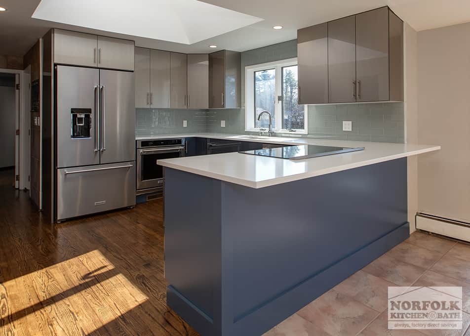 a gray and blue high-gloss kitchen with peninsula and stainless steel appliances