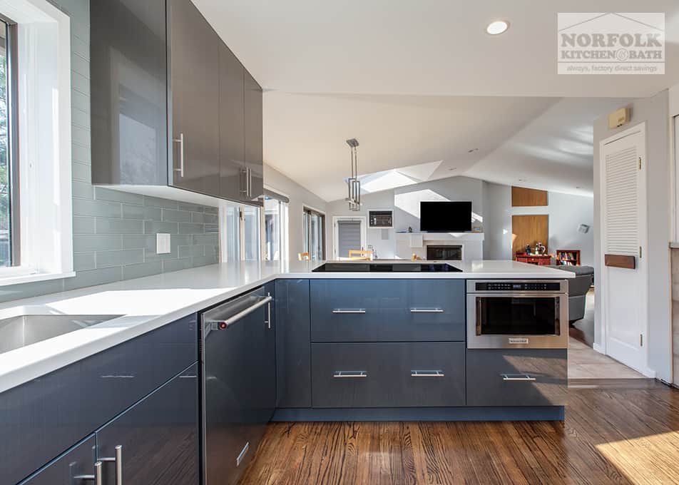 a modern, high-gloss, blue & gray kitchen with a peninsula facing into the great room