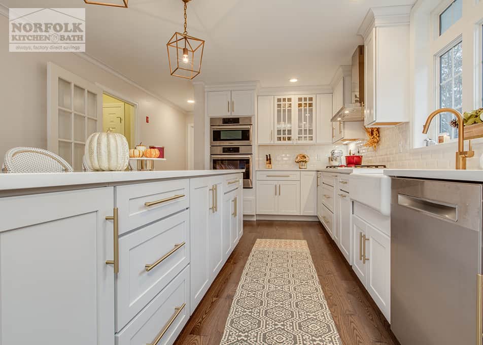 lower view of white kitchen cabinets with gold hardware and stainless steel appliances