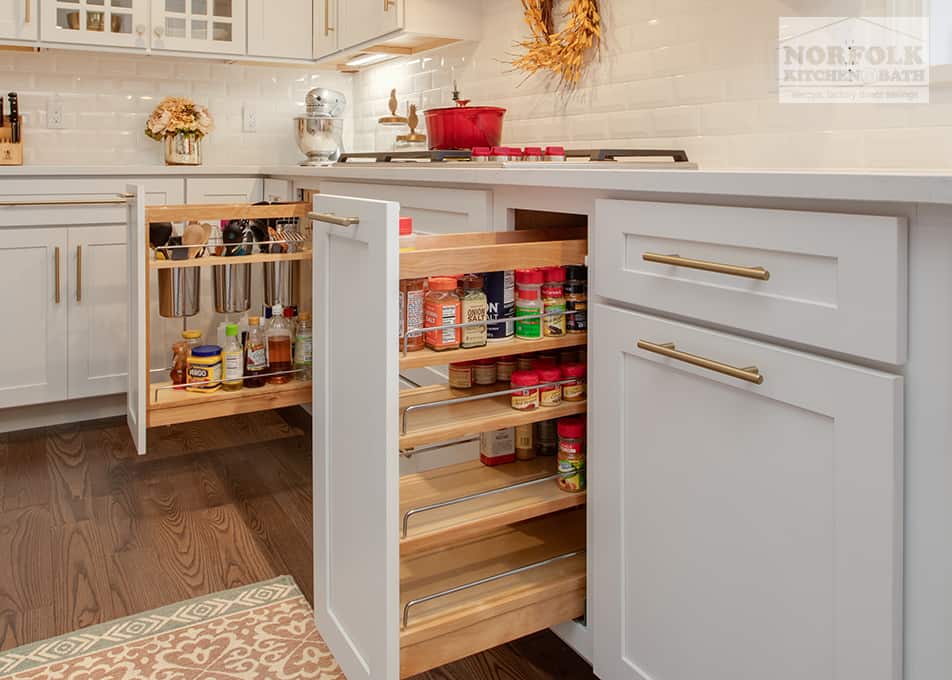 white kitchen cabinets with storage accessories on either side of the gas cooktop