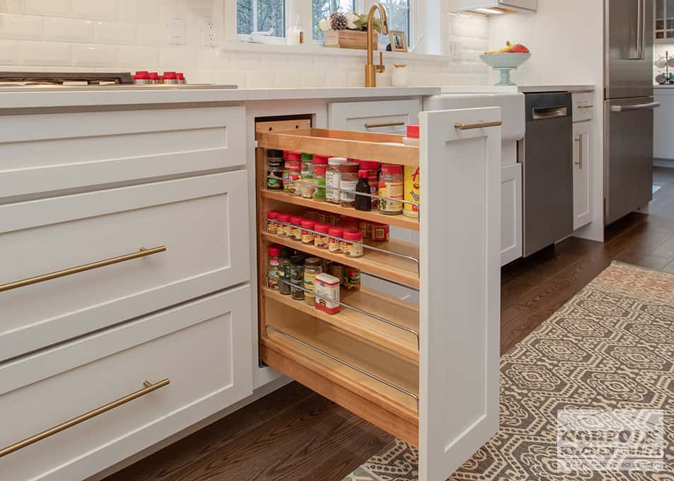 white kitchen cabinet with pull out spice storage