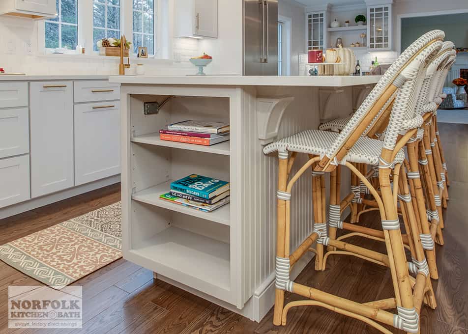 close up of a bookshelf on one end of a white kitchen island