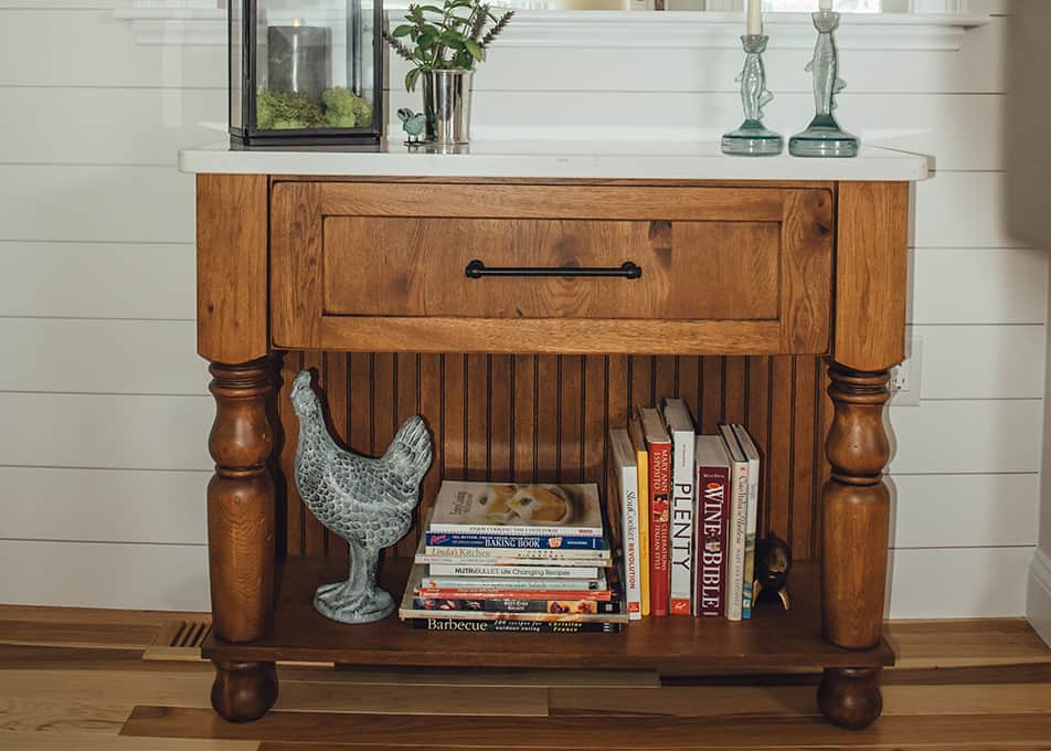 a wood furniture piece with books and decor