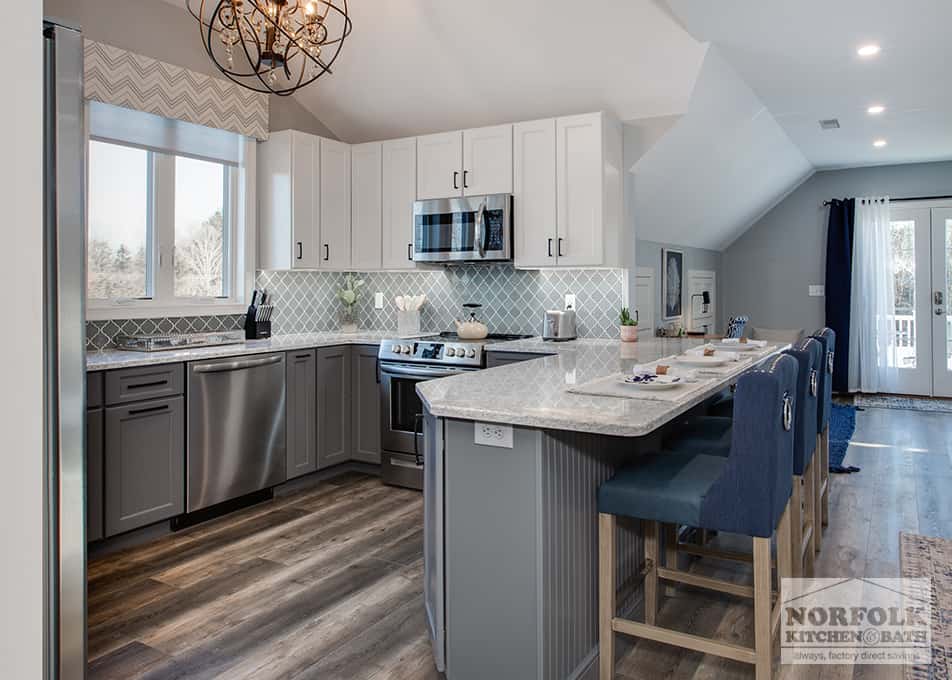 a kitchen remodel in Hampton Falls, NH featuring white and grey kitchen cabinets with a large peninsula 