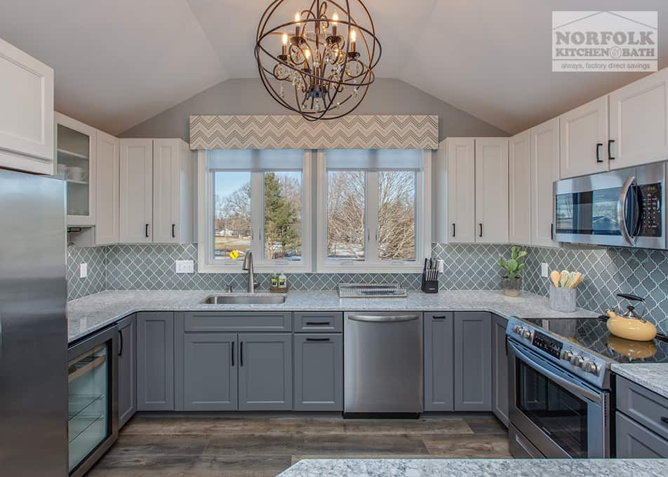 a kitchen remodel in Hampton Falls, NH featuring white and grey kitchen cabinets with a large peninsula 