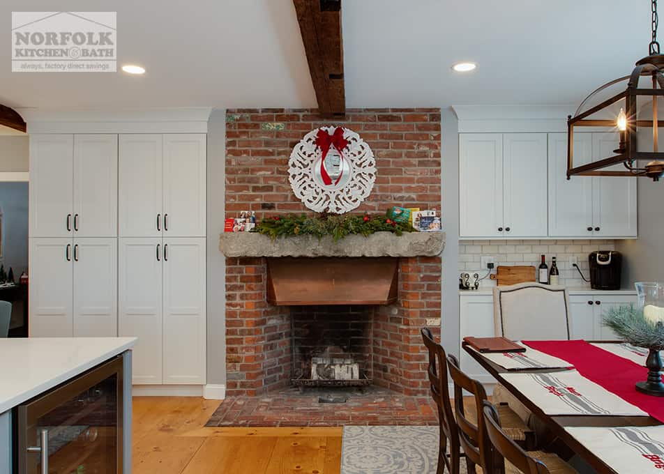 a large brick fireplace with a stone grey mantel and built in cabinets on either side.