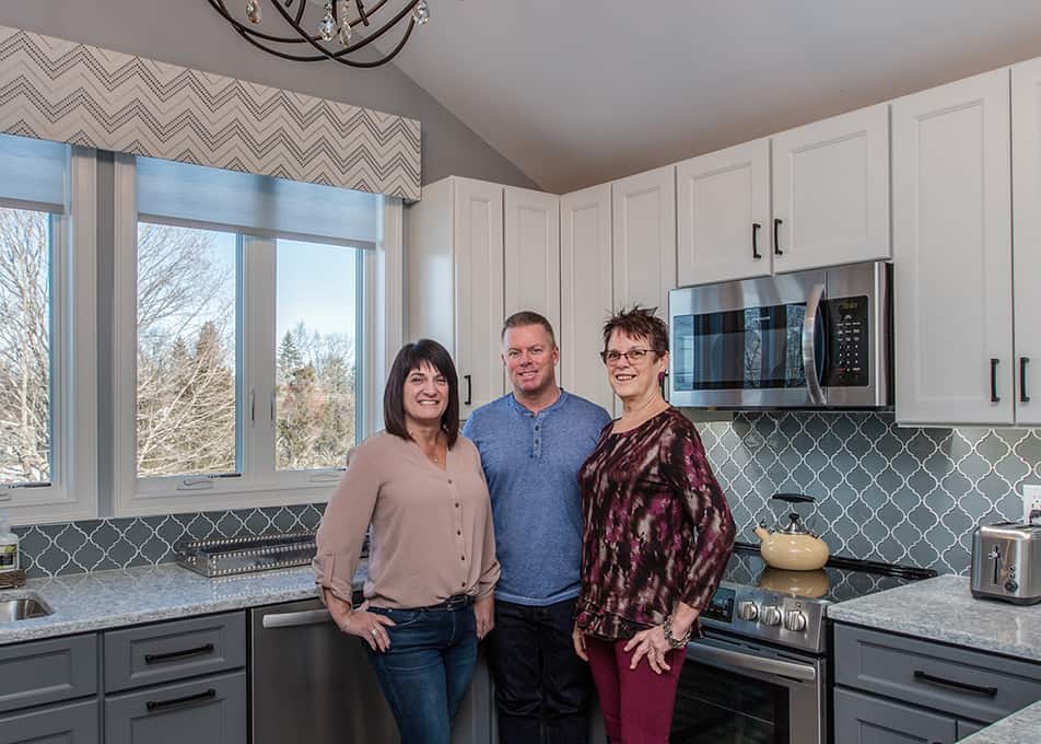 Louise Robie, a Norfolk Kitchen & Bath designer, posing with her clients in their new kitchen 