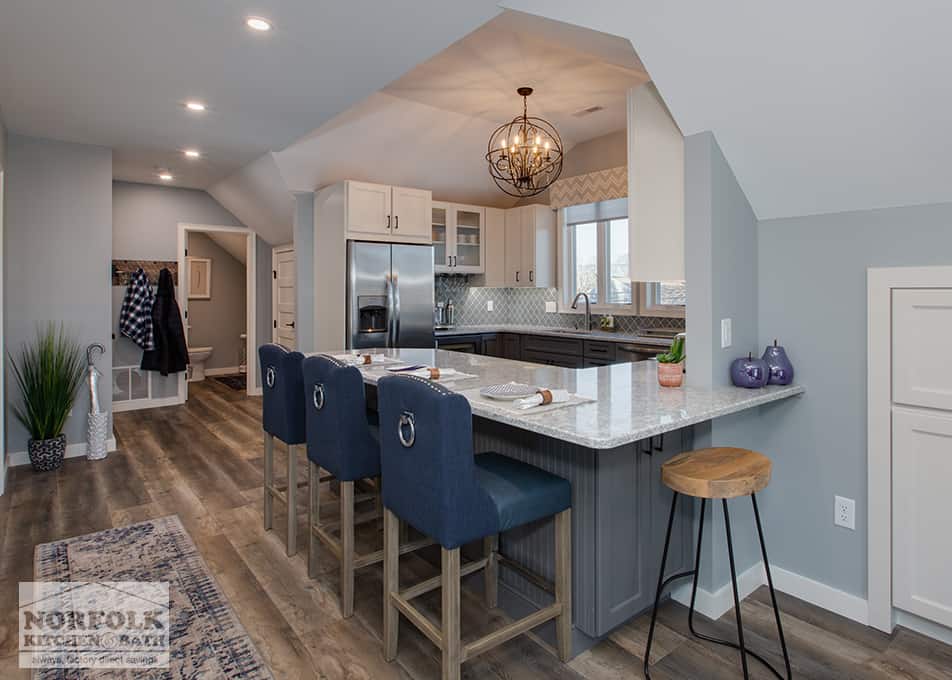 a kitchen remodel in Hampton Falls, NH featuring white and grey kitchen cabinets with a large peninsula and seating