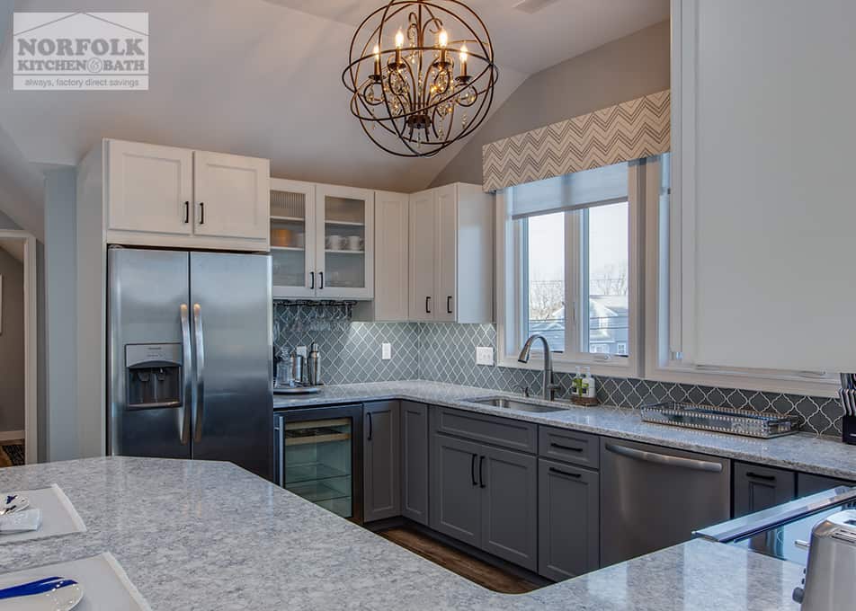 a kitchen remodel in Hampton Falls, NH featuring white and grey kitchen cabinets with a large peninsula 